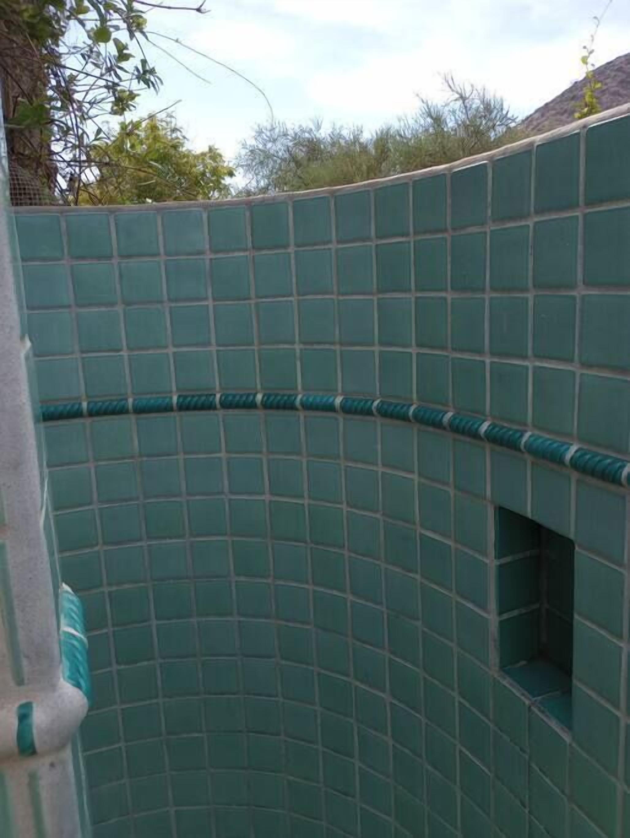A curved wall with a grid pattern, likely part of a building's exterior.