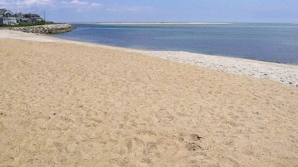 A sandy beach with a clear sky and calm sea. - The Whistling Whale - Fantastic Location!! (Chatham)