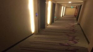 A hotel hallway with carpeted floors and walls lined with light fixtures. - Lavande Hotel Shanghai Zhangjiang Guanglan Road Me (Shanghai)