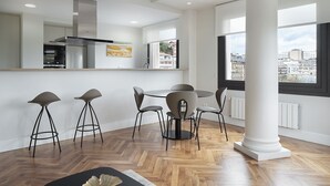 Cozinha moderna com ilha central, banquetas e mesa de jantar com cadeiras.