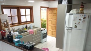A kitchen with a window, a sink, a stove, and a refrigerator. - Cozy Wooden House (Formiga)
