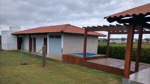 A residential property with a swimming pool, a covered patio, and a fenced yard. - Cozy Wooden House (Formiga)