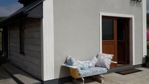 A small building with a single door and a bench outside. - Stunning Tory Island Apartment (Tory Island)