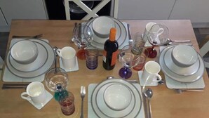 A dining table set with plates, glasses, and cutlery. - Stunning Tory Island Apartment (Tory Island)