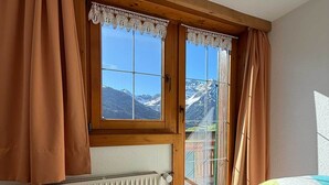 Una habitación con un ventanal grande, un radiador y una cama.