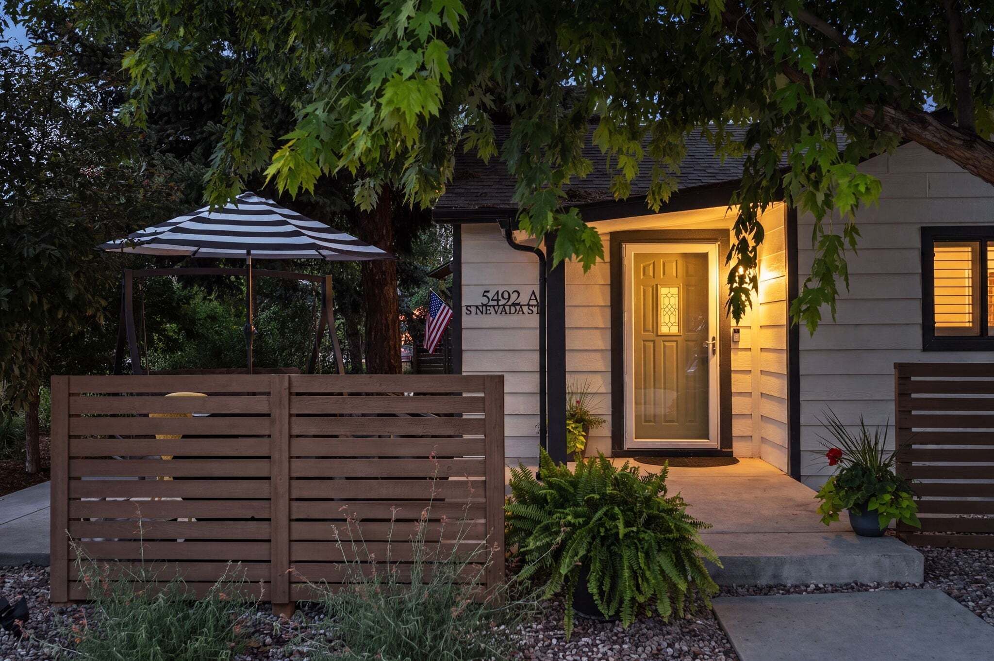 A residential property with a front door, a mailbox, and a street sign.
