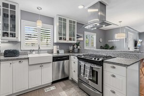 A modern kitchen with white cabinetry, stainless steel appliances, and a granite countertop. - Littleton Cottage🏡2 blocks to Main🛍️Pets🐶Fenced Yard♨️Firepit🤑0 Cleaning & Pet Fee (Littleton)