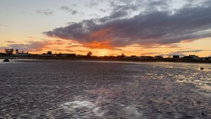 A sunset over a body of water with buildings in the background.