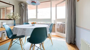 A dining area with a round table, chairs, a vase with flowers, and a bowl of fruit. - St Katharine Dock | By Tower Bridge | Dock View (London)