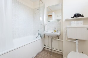 Une salle de bain moderne avec une douche à parois de verre, un lavabo blanc et des toilettes.