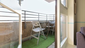 Een balkon met uitzicht, een tafeltje en twee stoelen.