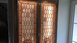 A wooden cabinet with glass doors, each labeled with vintage wine names and years.