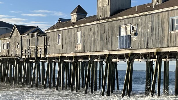 A wooden pier with multiple buildings extending over the water. - Seashell Cottages/JK Rentals -  The Daniel Unit (Old Orchard Beach)