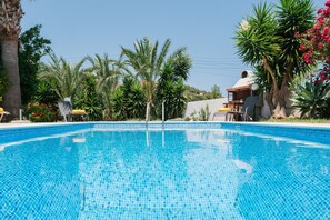 Piscine extérieure en saison, parasols, chaises longues