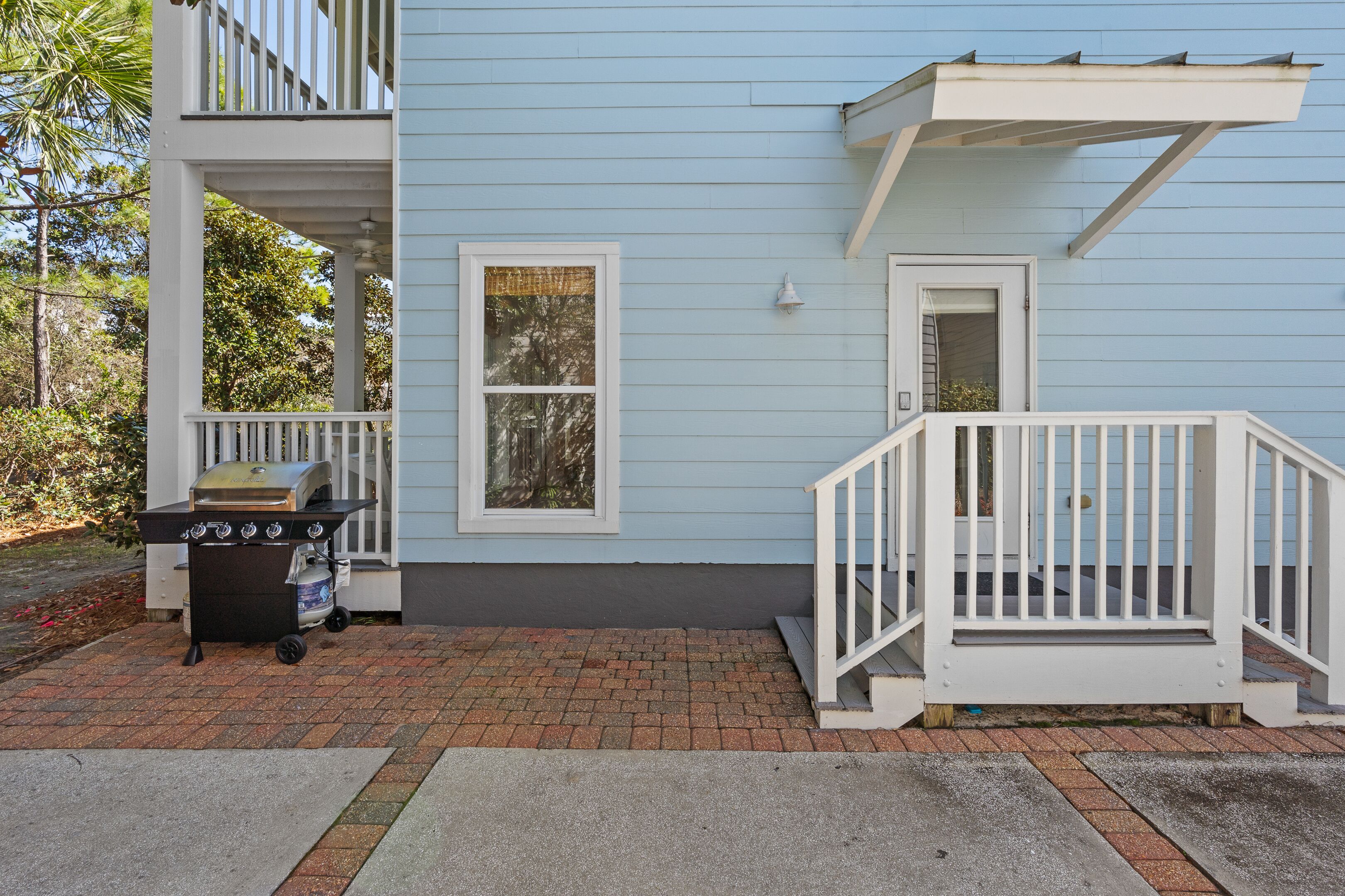A two-story house with a blue exterior, a covered porch, and a white railing.