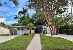 A residential property with a covered patio, a front door, and a pathway leading to the entrance. - Bright & Spacious 4 mi to BEACH +Big Backyard (Miami)