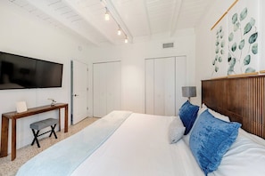 A bedroom with a bed, a desk, a television, and a wall with artwork. - Bright & Spacious 4 mi to BEACH +Big Backyard (Miami)