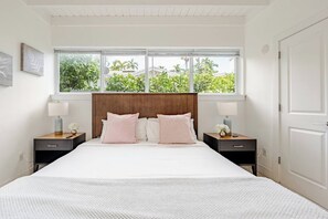 A bedroom with a large bed, two bedside tables, a wooden headboard, and a window with a view of greenery. - Bright & Spacious 4 mi to BEACH +Big Backyard (Miami)