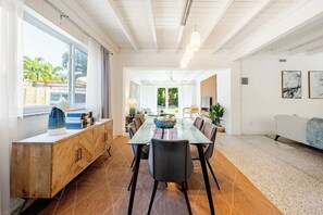 A spacious dining area with a long table, chairs, and a wooden cabinet. - Bright & Spacious 4 mi to BEACH +Big Backyard (Miami)