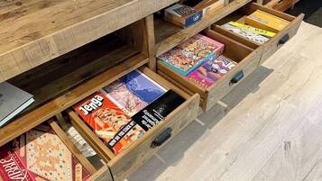 Een houten kast met meerdere lades vol met verschillende bordspellen.