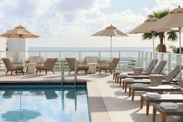 Utomhuspool, parasoller och solstolar