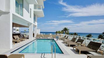 Een buitenzwembad, parasols voor strand/zwembad