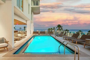 室外游泳池，池畔遮阳伞，日光浴躺椅