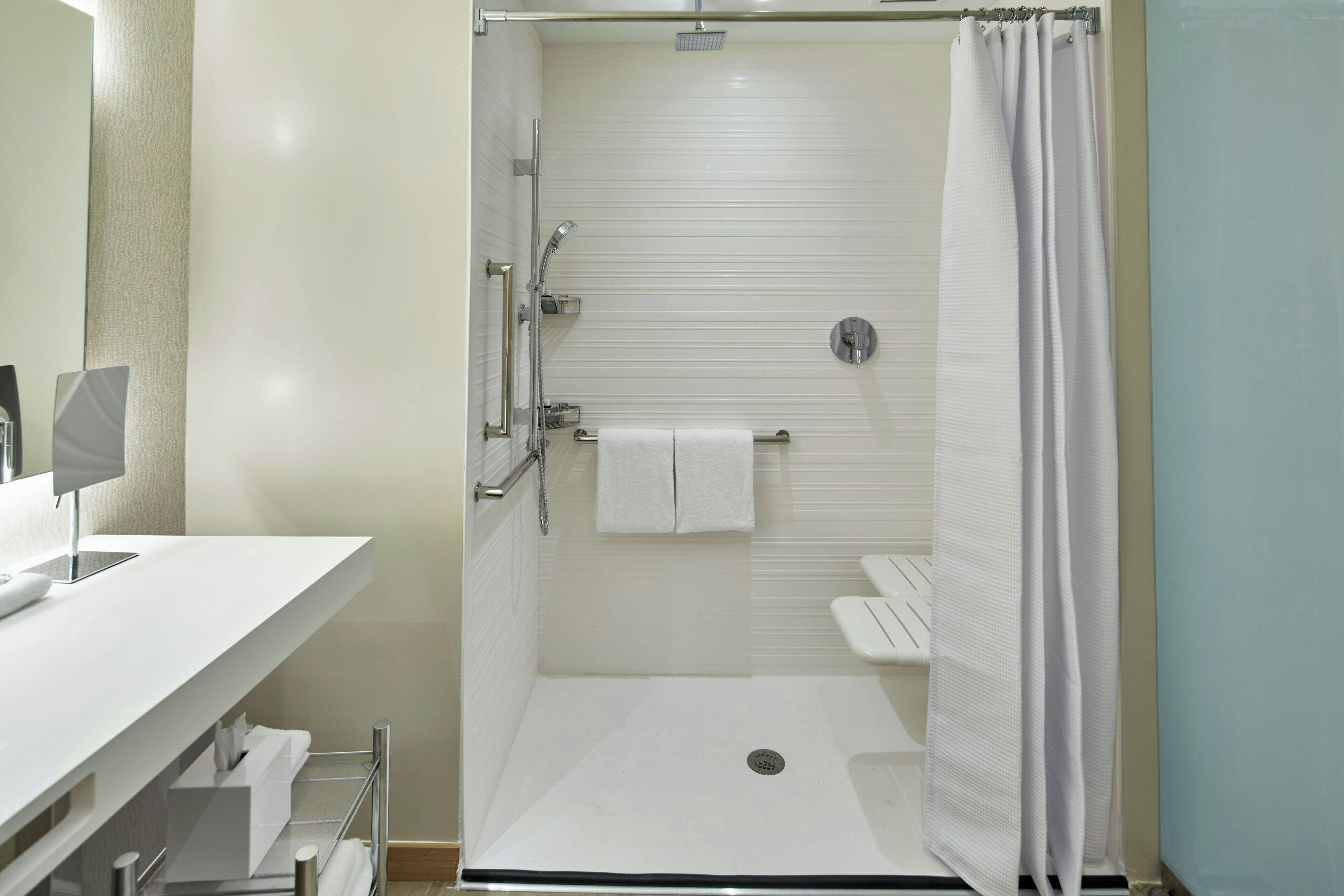 Een moderne badkamer met een inloopdouche, toilet en wastafel.
