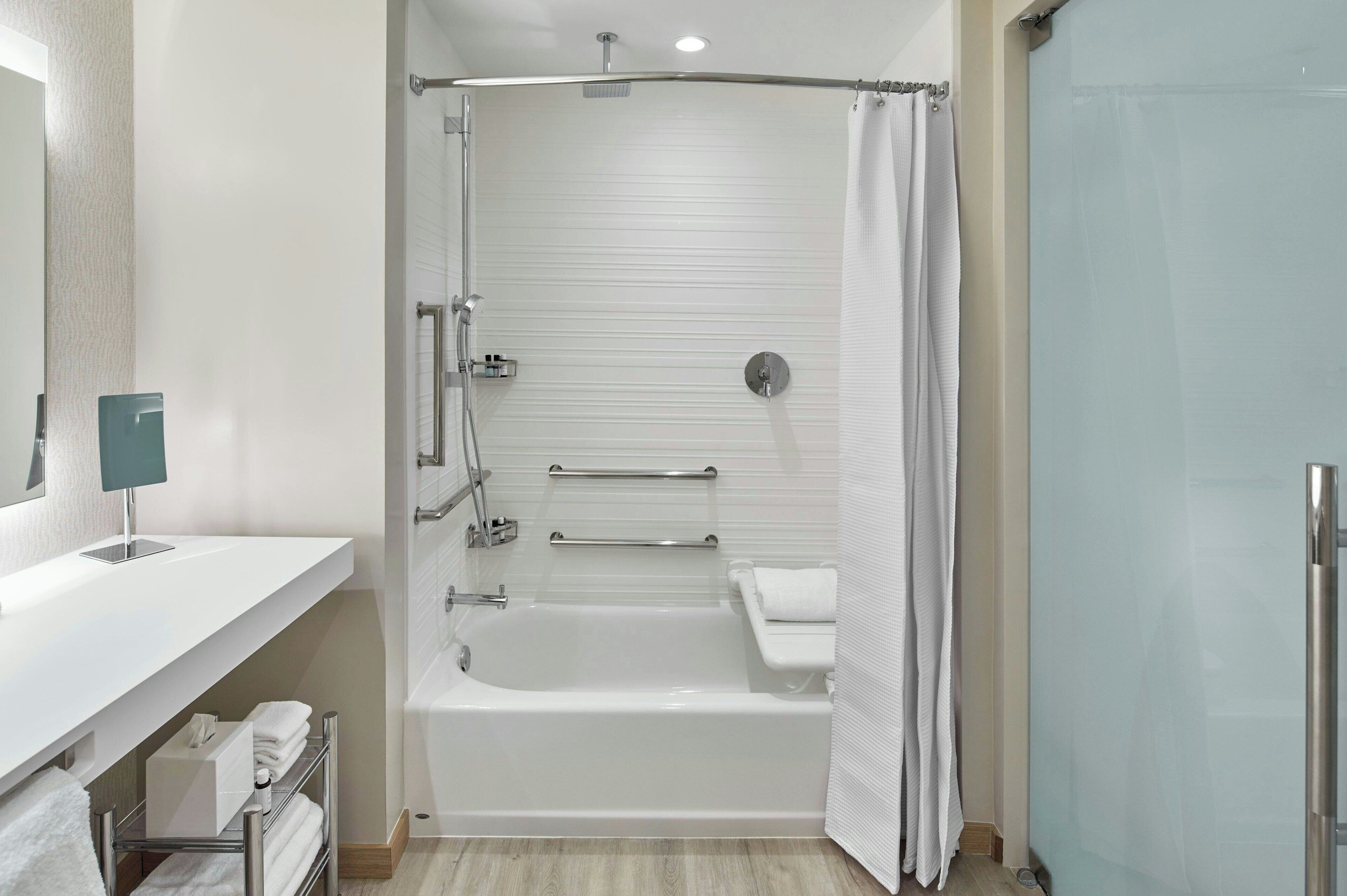 A modern bathroom with a bathtub, shower, and toilet.