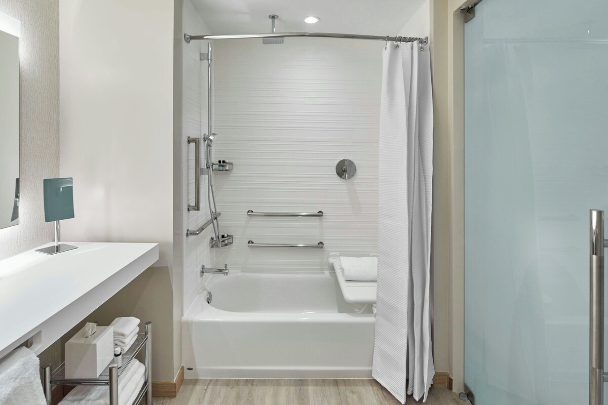 Une salle de bain moderne équipée d’une baignoire, d’une douche et de toilettes.