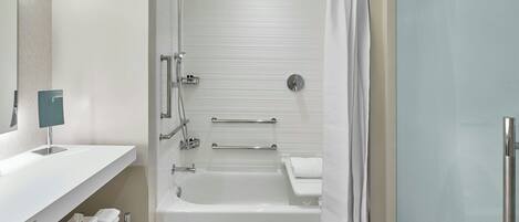 A modern bathroom with a bathtub, shower, and toilet.