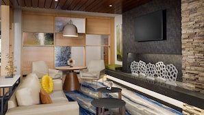 Una sala de estar moderna con sofá, sillas, una mesa de centro y chimenea.