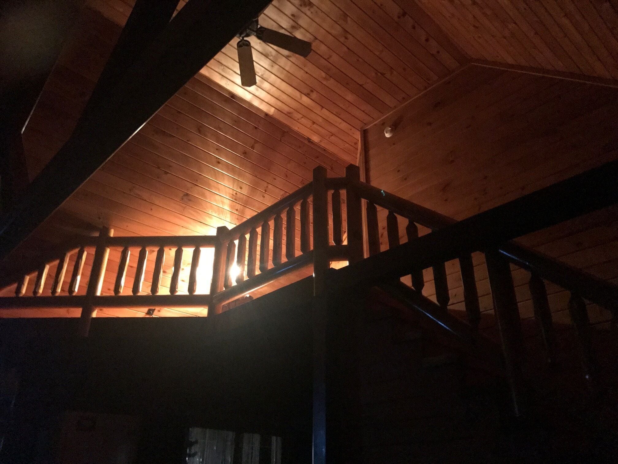 Un escalier en bois avec une rampe menant à un niveau supérieur.