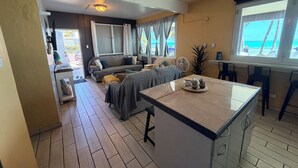 Un salon confortable avec un canapé, une table à manger et un îlot de cuisine.