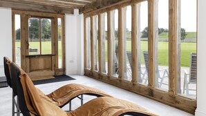 Une chambre avec un lit, de grandes fenêtres et une vue sur l’extérieur.