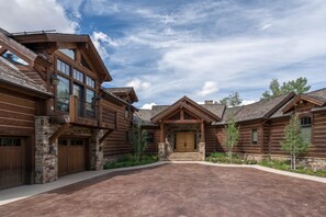 A log cabin with a spacious driveway, stone foundation, and a prominent front entrance. - THE Pinnacle by Exceptional Stays (Telluride)