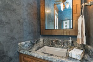A bathroom with a marble sink, a large mirror, and a towel rack. - THE Pinnacle by Exceptional Stays (Telluride)