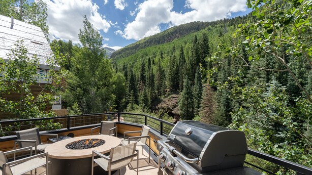 An outdoor patio with a round table, chairs, and a grill. - THE Tributary by Exceptional Stays (Telluride)