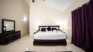 A bedroom with a bed, a ceiling fan, a TV, and a dark-colored dresser. - VIP Sosúa Villa | Private Pool & Pool Table (Sosúa)