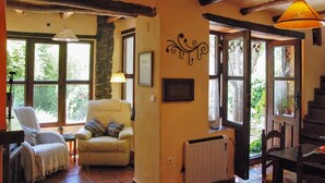 Un salon chaleureux avec une grande fenêtre, une cheminée et un coin salon confortable.