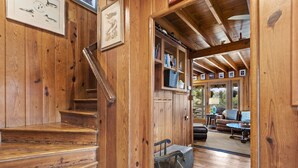 A wooden staircase leading to a living area with a sofa and a table.