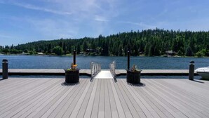 A wooden dock leading to a calm lake with dense forest in the background. - Chic Condo Steps from Spokane River And Dining (Coeur d'Alene)