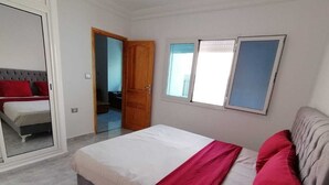 Ein Schlafzimmer mit einem Bett, einem Kleiderschrank und einer Tür zu einem anderen Raum.