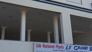 Ein mehrstöckiges Gebäude mit Café, Restaurant und Pizzeria im Erdgeschoss.