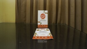 A brochure on a glass table with a curtain backdrop. - Oyo 2902 Graha 18 (Surabaya)