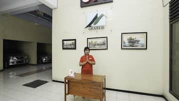 A person standing in front of a wall with the 'OYO' logo and three framed artworks.