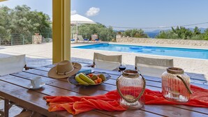 Ein Tisch am Pool mit einem Hut, einer Obstschale und zwei Glasbehältern.