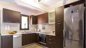 Eine moderne Küche mit dunklen Holzschränken, Edelstahlgeräten und einem großen Kühlschrank.