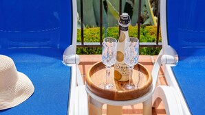 A lounge chair with a bottle of Lolei Brut champagne and three glasses on a wooden tray. - Villa Maroma Viñuela by Ruralidays (Málaga)