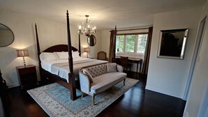 A four-poster bed with a chandelier, a sofa, a desk, and a large mirror in a bedroom with a view of the outdoors. - Arrowstone Luxury Farmhouse in Historic Old Town, Niagara-on-the-Lake.  (Niagara-on-the-Lake)